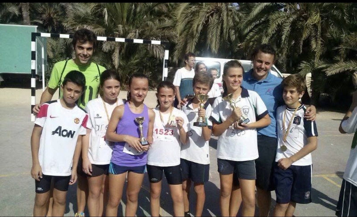Chicos y chicas de la escuela de Juventud Atlética Elche con sus trofeos y medallas tras una carrera