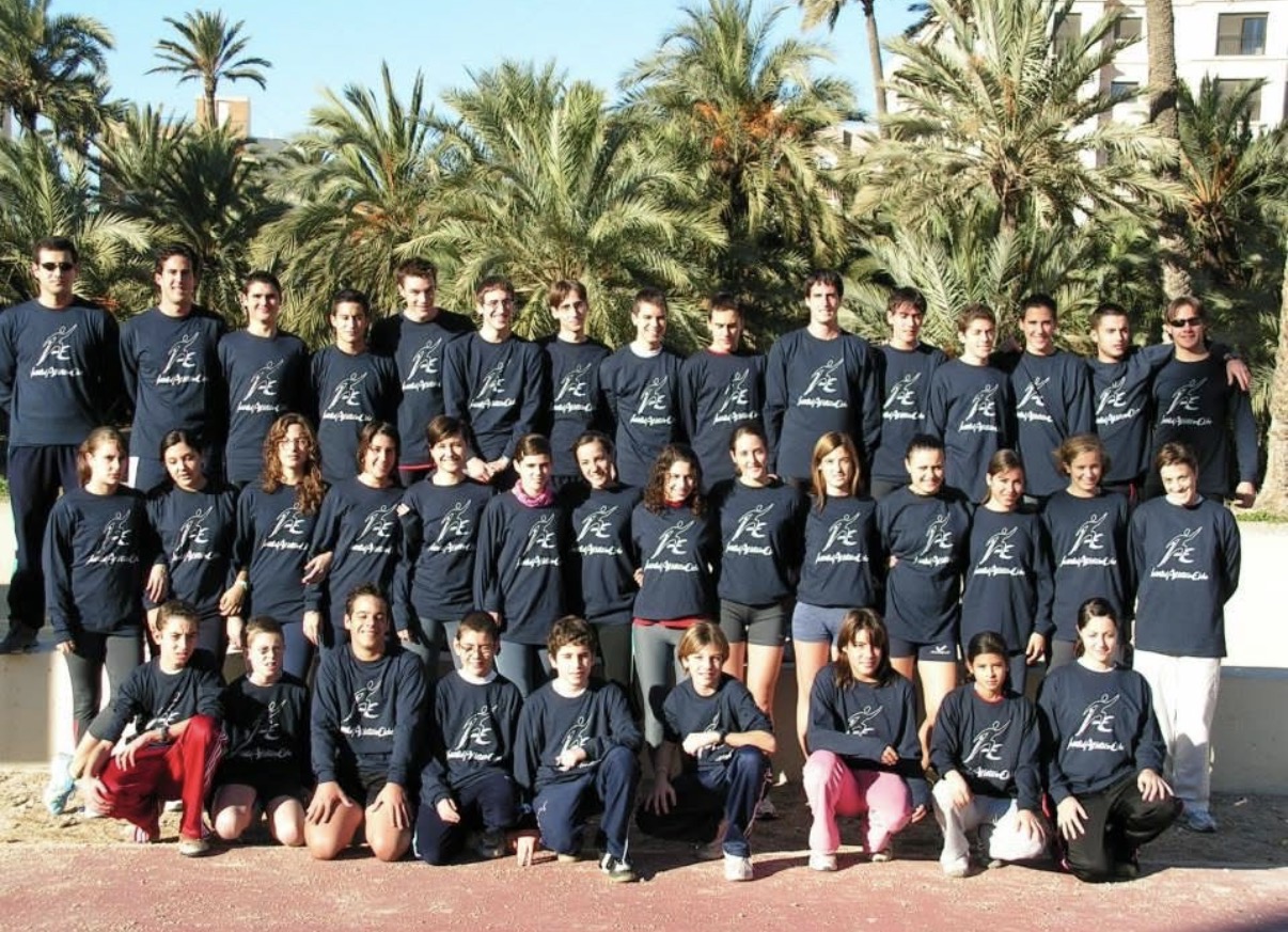 El equipo de Juventud Atlética Elche al completo, con la camiseta del club, entre las palmeras
