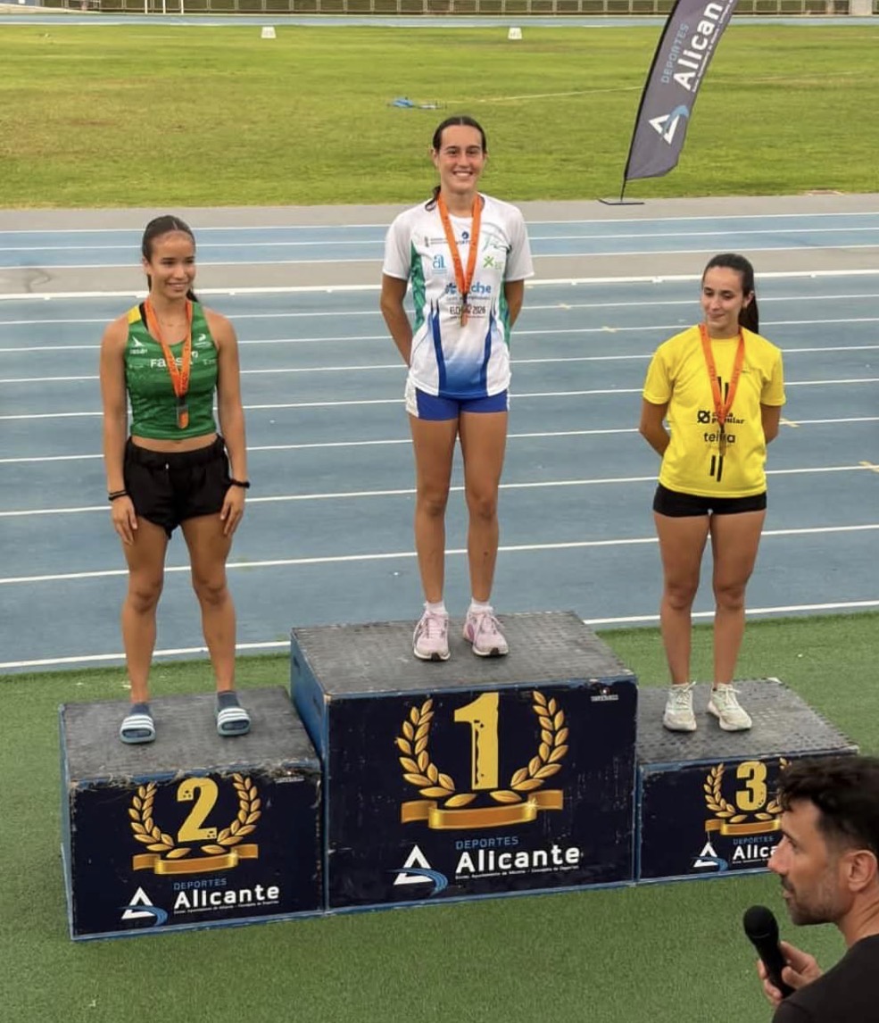 Atleta de Juventud Atlética Elche en lo alto del podio, primera clasificada, en la pista de Alicante